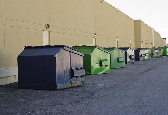 a waste management truck unloading into a construction dumpster in Chetek